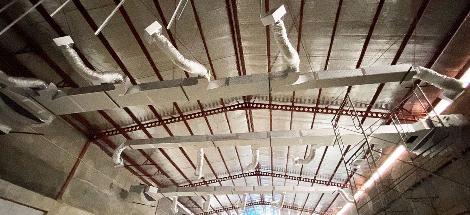 Jalur ducting dan diffuser di bawah atap aula yang luas