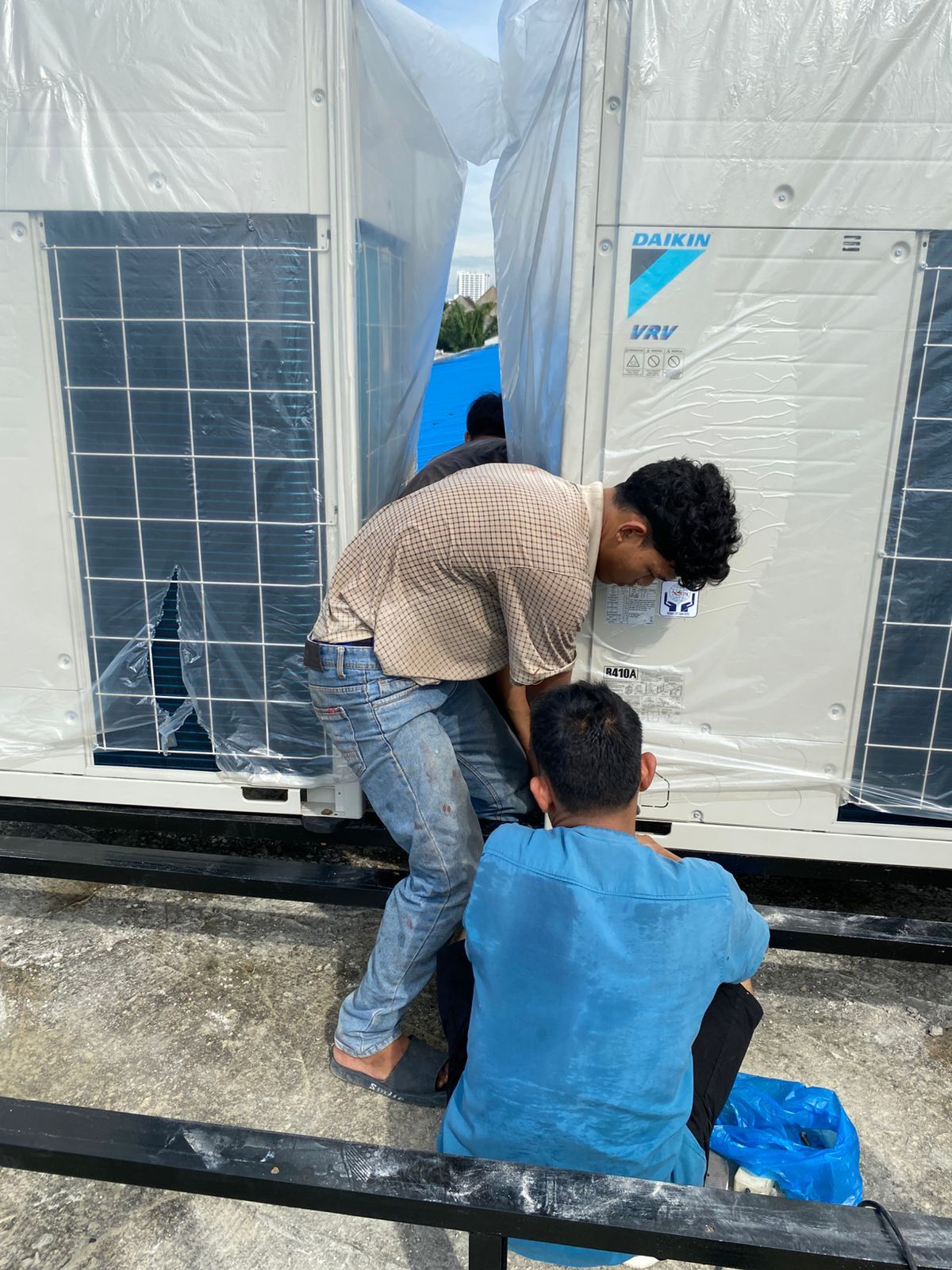 Teknisi memasang outdoor unit Daikin VRV di atap